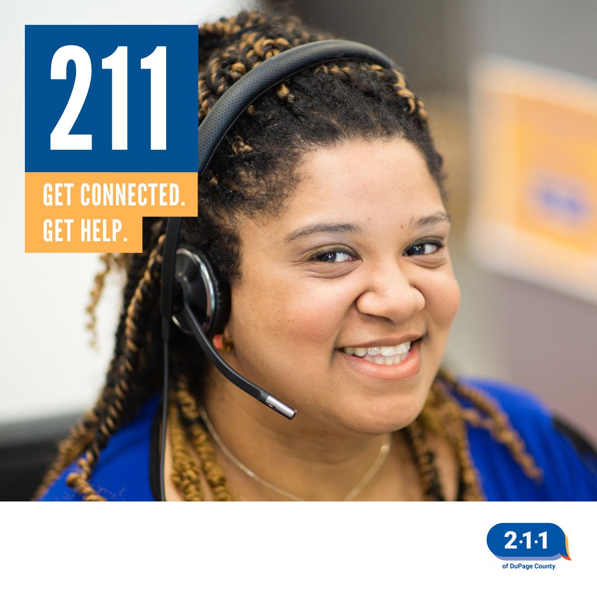 A photo of a woman wearing a headset waiting to help someone who calls 211.