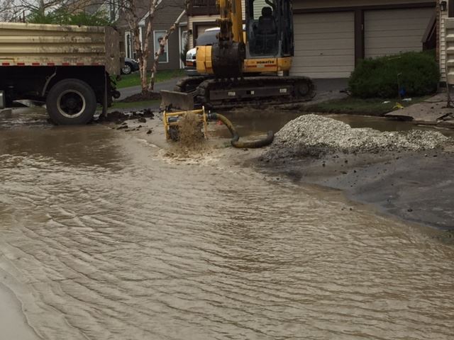 Image of a water main break flooding a street